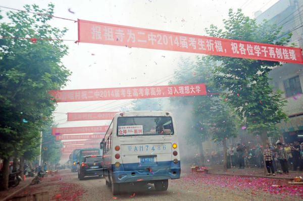 運送考生的車輛依次駛出校門，路邊鞭炮點燃,，鑼鼓喧天,。