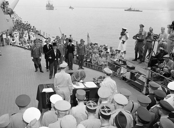 1945年9月2日上午9時(shí),，東京灣,，密蘇里號(hào)戰(zhàn)列艦上的日本投降文件簽署儀式。這張照片里,，梅津美治郎將軍代表日本武裝力量簽署投降書(shū)，（他身后戴著大禮帽的）日本外相重光葵之前已經(jīng)代表日本政府簽字,。