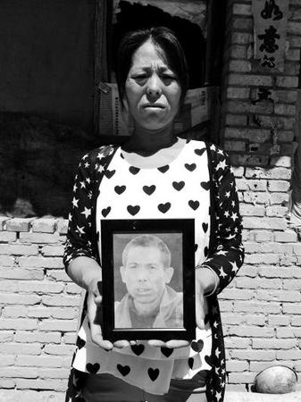 李艮花抱著大哥的遺像,。京華時報記者施志軍攝