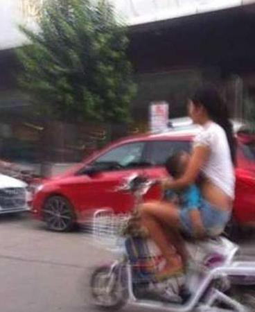媽媽邊騎車邊給孩子喂奶,。