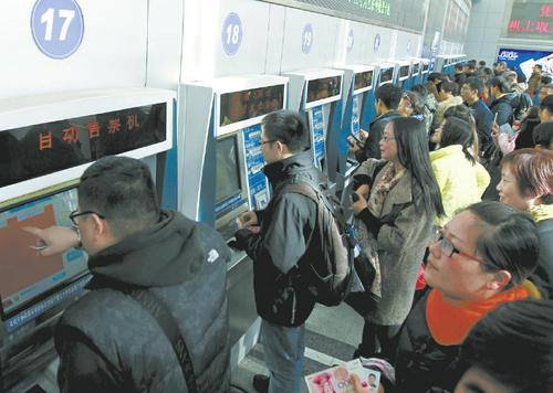 12月7日,，乘客在上?；疖囌镜淖灾燮贝髲d內(nèi)購買火車票,。