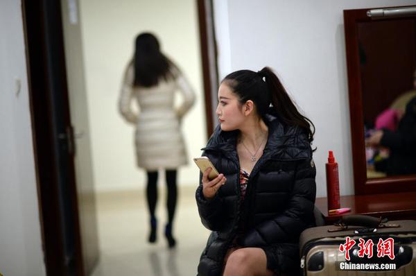 　　換裝后，舉牌女郎在化裝室休息。中新社發(fā) 稻草 攝 圖片來(lái)源：CNSPHOTO
