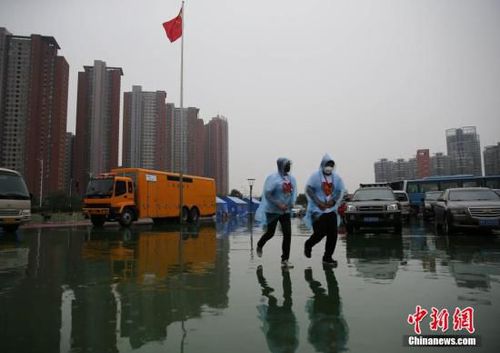 8月18日,，天津泰達二小安置點內的兩名志愿者跑回樓內避雨,。當日10時,，天津港“8·12”特別重大火災爆炸事故所在區(qū)域下起中雨,。中新社發(fā) 楊可佳 攝