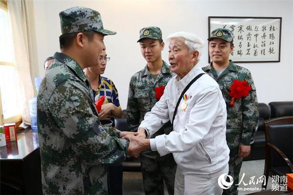 抗戰(zhàn)老兵方耀寰握住入伍新兵的手,，囑咐他們要收好香港地區(qū)的繁榮與和平，在軍隊努力學習,，為國貢獻,。 胡丹  攝