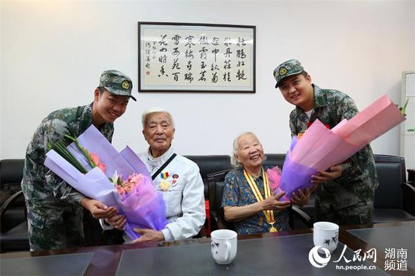 岳麓區(qū)即將去往駐港部隊的新兵代表為抗戰(zhàn)老兵方耀寰,、惲順芳送上鮮花與月餅，祝福老人節(jié)日快樂,。 胡丹 攝