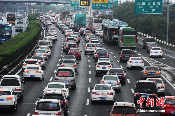 10月1日，江蘇蘇州,，國慶長假高速公路免費(fèi)通行第一天,，沿江高速江蘇省太倉主線收費(fèi)站附近出現(xiàn)數(shù)百米的車流長龍，從上海方向駛出的大量車輛緩慢通行經(jīng)過沿江高速江蘇太倉段,。計(jì)海新 攝 圖片來源 CFP視覺中國