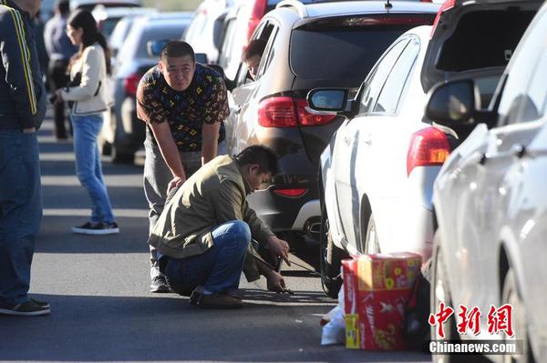 10月1日，十一黃金周第一天,，受出京自駕游玩車(chē)輛增多影響,，京滬高速泗村店路段嚴(yán)重?fù)矶?。圖為一位司機(jī)正在換輪胎,。小可 攝 圖片來(lái)源 CFP視覺(jué)中國(guó)