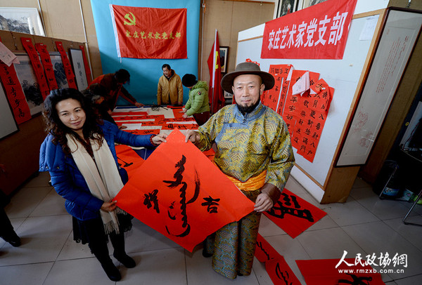 北京宋莊藝術(shù)家黨支部書記巴特爾把用蒙漢兩種文字寫好的春聯(lián)送給蒙族在京的老鄉(xiāng),，祝愿新年吉祥,。_副本