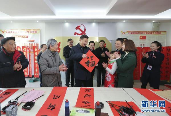 這是2月3日,，習(xí)近平在南昌市東湖區(qū)彭家橋街道光明社區(qū)書畫室，接過一位小朋友現(xiàn)場書寫的 “?！弊?，祝大家都幸福。 新華社記者蘭紅光攝