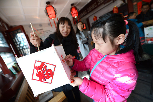 14A圖為孩子們在家長的陪同下扎燈籠，描畫圖案,。