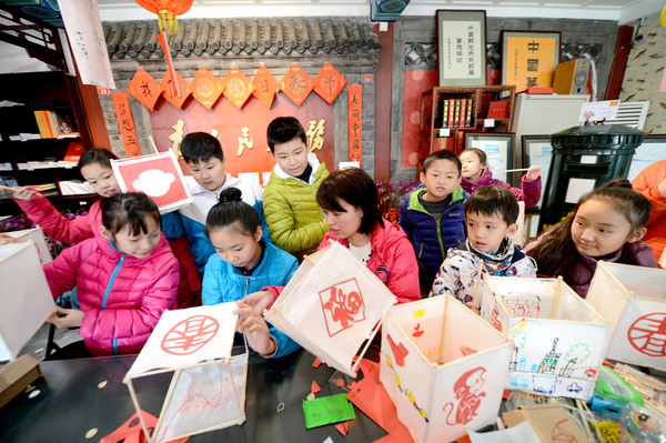1A圖為孩子們?cè)诒本┑膲?mèng)想驛站里扎燈籠，體驗(yàn)民俗,。