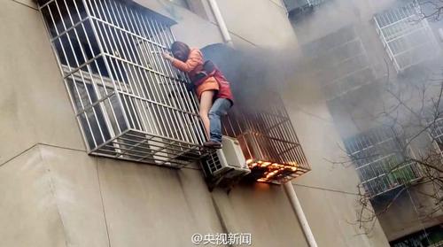 近日，湖北一戶居民家著火冒出滾滾濃煙,，一女子被防盜網(wǎng)困?。γ嫘^(qū)整理包裹的快遞員張洋見狀跑來,，徒手爬上陽臺,，用手肘使勁撞開防盜網(wǎng)，終將女子救出！（央視記者吳紹鈞）