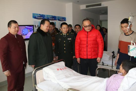 姬軍生院長（左二）、俆鐿軒（左四）,、吳宗霖（左一）在醫(yī)院其他領(lǐng)導(dǎo)陪同下看望包蟲病患者