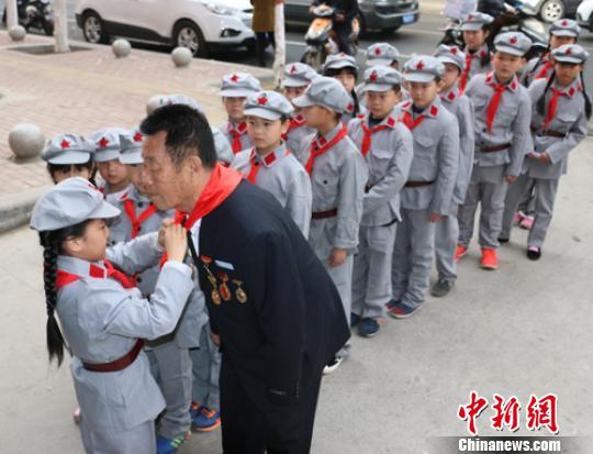 受谷殿明血雷鋒事跡的感染，雷鋒小標(biāo)兵為這位“活雷鋒”爺爺系上紅領(lǐng)巾,?！」鶊@ 攝
