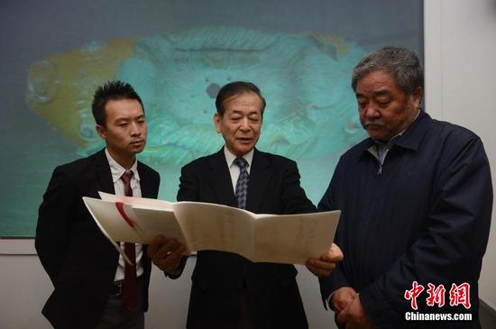 　　3月28日，牟田口章人（圖中）向內(nèi)蒙古博物院院長（圖右）介紹捐贈的文獻,。當日,，日本帝塚山大學文化創(chuàng)造學科教授牟田口章人在呼和浩特，向內(nèi)蒙古博物院捐贈了遼代文物“雙魚形琉璃釉建筑構(gòu)件”,。據(jù)悉,，該文物是他在日本自己出資購得，同時他還代友人捐助了遼代歷史研究文獻,。中新社記者 劉文華 攝