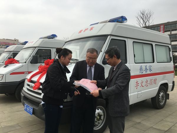 李文忠（中）與畢節(jié)市衛(wèi)計委工作人員辦理巡診車交付使用的手續(xù),，右為畢節(jié)市衛(wèi)計委主任鄧韜,。