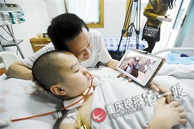 孩子蘇醒后，父親程軍拿出平板電腦和他一起回憶過去美好的生活,。