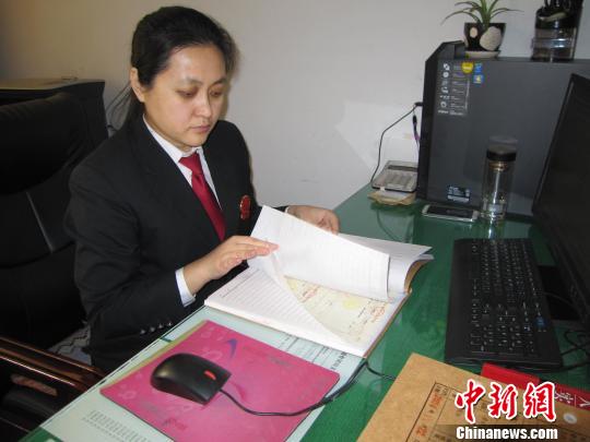 圖為劉彥在翻閱案卷,?！±钪矣?攝