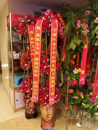 酒店門口擺有不少賓客送來(lái)的祝?；ɑ@,，其中一個(gè)花籃署名為“亭湖區(qū)永豐中心幼兒園全體教職工賀”,。