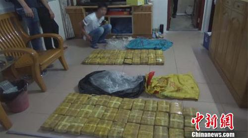 圖為現(xiàn)場抓獲的犯罪嫌疑人及繳獲的毒品?！垊P 攝
