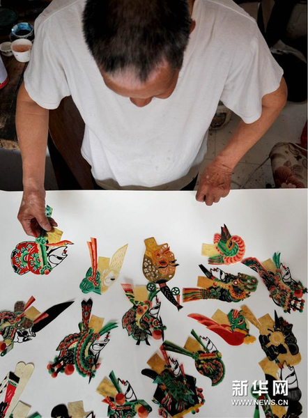6月5日,，張奎老人在家中展示制作的皮影
