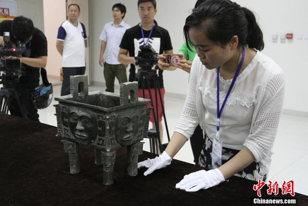 參展博物館代表檢查文物“大禾人面紋方鼎”,。 中新社記者 鐘欣 攝