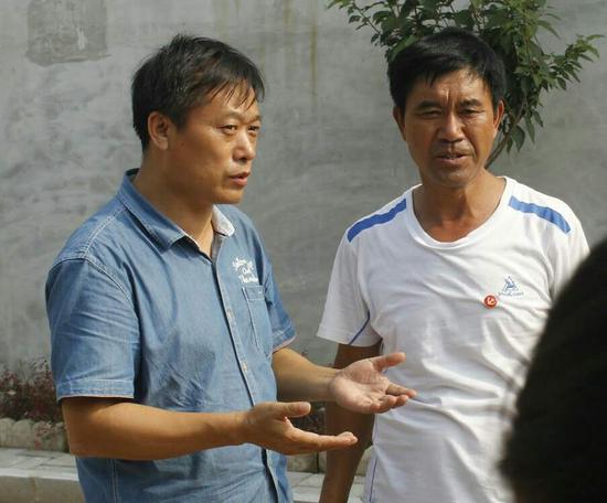 楊牌村黨支部書記向范德俊介紹該村受災(zāi)情況,。