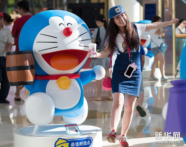 7月31日,，一名市民在哆啦A夢卡通造型旁拍照,。