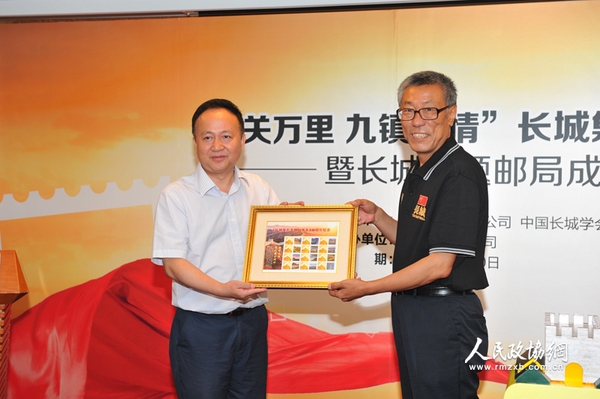 中國集郵總公司總經(jīng)理鄧慧國向中國長城學(xué)會(huì)副會(huì)長董耀會(huì)贈(zèng)送《長城保護(hù)條例頒布10周年紀(jì)念》個(gè)性化郵票