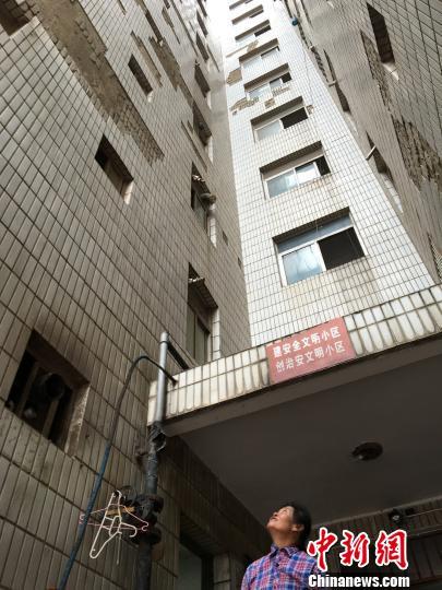 圖為白馬小區(qū)高層樓道口上方,，墻磚脫落嚴(yán)重?！】姵?攝