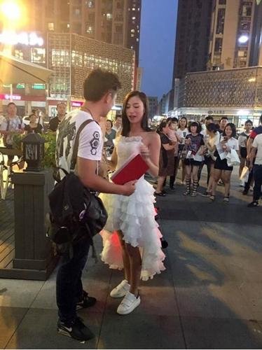 送哈雷送房子，只為博男神一個點頭,！此番情景瞬間吸引了大量路人圍觀,。被求婚的男生，明顯點驚慌,，面對突然發(fā)生的一切,，顯得毫無準(zhǔn)備且難以置信。