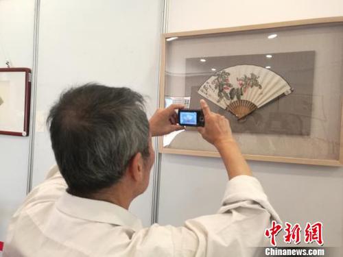 圖為中國書畫家協(xié)會理事,、臺灣中華大漢書藝協(xié)會特聘書畫大師翟因欽在拍照,。　蘇路程 攝