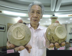 圖為聞長(zhǎng)慶展示刻有類希臘字母的古越青瓷器,。（南華 攝） 