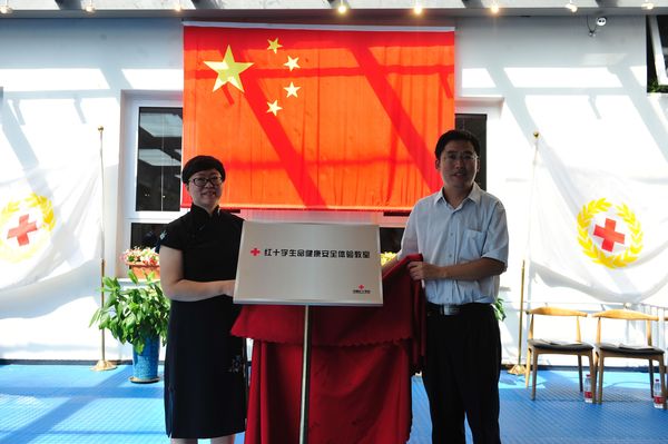北京首家紅十字生命健康安全體驗教室落戶北京燈市口小學,，中國紅十字會總會賑濟救護部救護處張立副調(diào)研員與燈市口小學滕亞杰校長共同為體驗教室揭牌
