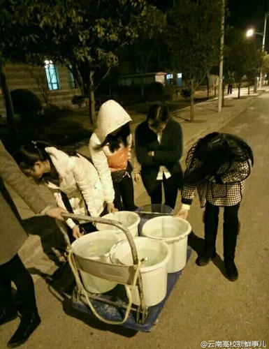 圖為學(xué)生將水運(yùn)回寢室,。