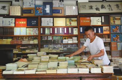 書店老板老劉在整理小人書,。