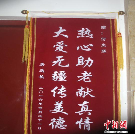 唐逸敏侄女贈(zèng)送的錦旗掛在社區(qū)走廊的墻壁上,?！顤| 攝