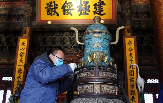 北京故宮太和殿,，專家正在清理太和殿內(nèi)青銅器上的灰塵。