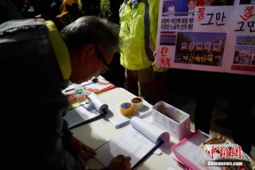 10月29日晚,，近兩萬(wàn)名韓國(guó)民眾及民間團(tuán)體人士在首爾市中心舉行燭光集會(huì),，譴責(zé)“親信干政事件”給韓國(guó)社會(huì)帶來(lái)的不良影響，要求總統(tǒng)樸槿惠對(duì)此事負(fù)責(zé),。圖為民眾在集會(huì)現(xiàn)場(chǎng)寫(xiě)下請(qǐng)?jiān)笗?shū),，要求查明事情真相。<a target='_blank' href='http://www.chinanews.com/'>中新社</a>記者 吳旭 攝