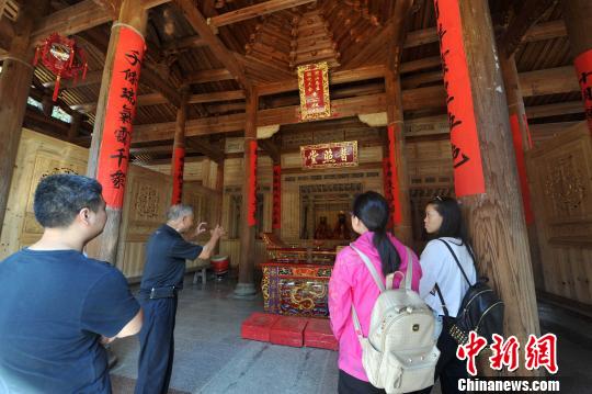 　　圖為70余歲的退休教師林樂妙（左二）擔(dān)任起普照堂的“講解員”,，每天義務(wù)為外地來的游客追古溯今,?！埍蟆z