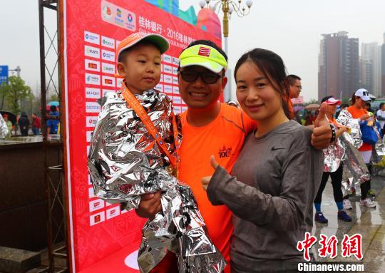 來自廣州的李強(qiáng)夫婦用兒童車，載著4歲的兒子,，一家三口完成了在桂林舉行的半程馬拉松比賽,。　歐惠蘭 攝