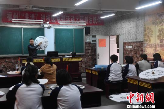 嚴(yán)磊在課堂上講授如何進(jìn)行油紙傘包頂,，17名學(xué)生紛紛抬起頭聽講,。　呂明 攝