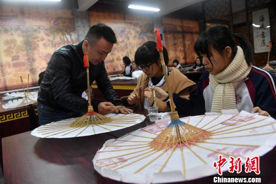 課堂上,，嚴(yán)磊手把手地教導(dǎo)學(xué)生如何制作油紙傘?！蚊?攝