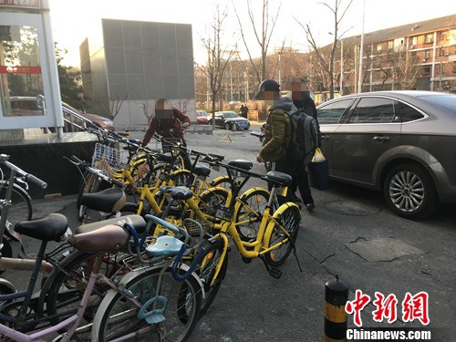 在北京街頭的一處共享單車停車點，有小孩在嘗試解鎖,。湯琪 攝