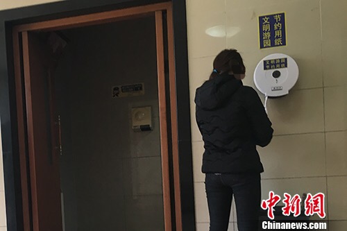 “節(jié)約用紙”的標(biāo)識不僅貼在墻上,，也貼在了取紙器上,。湯琪 攝