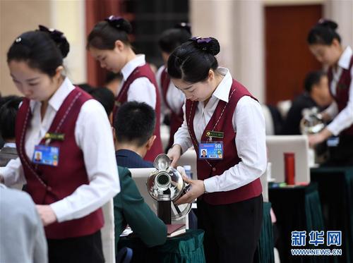 3月6日，北京華北賓館的女服務(wù)員在民盟,、無(wú)黨派人士界委員聯(lián)組會(huì)上倒水,。在兩會(huì)會(huì)場(chǎng)內(nèi)外，女代表,、女委員,、女工作人員、女記者在工作中盡職盡責(zé),，展現(xiàn)著自己的風(fēng)采,。 新華社記者張鐸攝