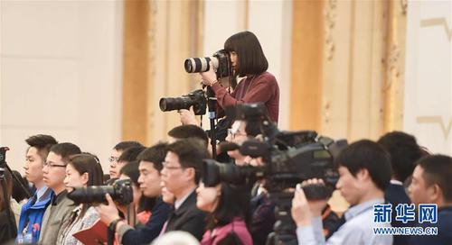 3月7日,，一名女記者在十二屆全國(guó)人大五次會(huì)議江蘇代表團(tuán)全體會(huì)議上采訪拍攝,。在兩會(huì)會(huì)場(chǎng)內(nèi)外，女代表,、女委員,、女工作人員、女記者在工作中盡職盡責(zé),，展現(xiàn)著自己的風(fēng)采,。 新華社記者陳曄華攝