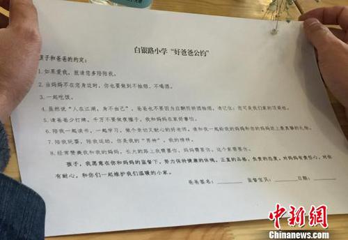 圖為家長閱讀“好爸爸公約”,?！⒂裉?攝