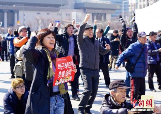 3月10日,，在象征著韓國政治中心的首爾光化門廣場,，民眾在聽到憲法法院對總統(tǒng)樸槿惠彈劾案的審判結果后歡呼。韓國憲法法院當日作出裁決,，宣布彈劾案成立,。樸槿惠成為韓國歷史上首位被彈劾罷免的總統(tǒng)。<a target='_blank' href='http://www.chinanews.com/'>中新社</a>記者 吳旭 攝