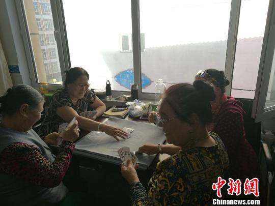 圖為進城牧民在一起打撲克,?！±類燮?攝